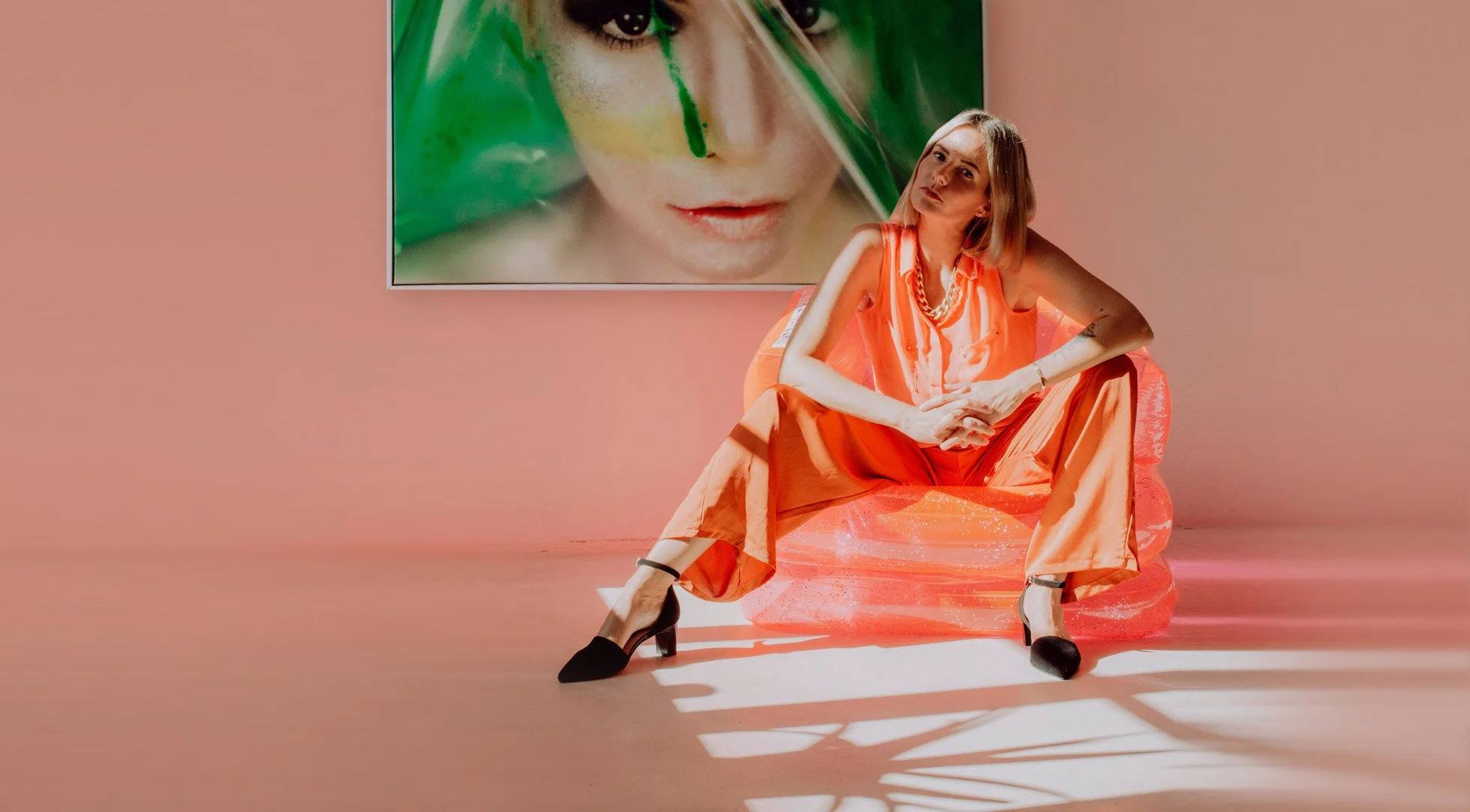 Fashion Portrait von Julia Feldmann von Hey Poly Photoart Studio, wie sie vor ihrem Portrait Kunstwerk sitzt