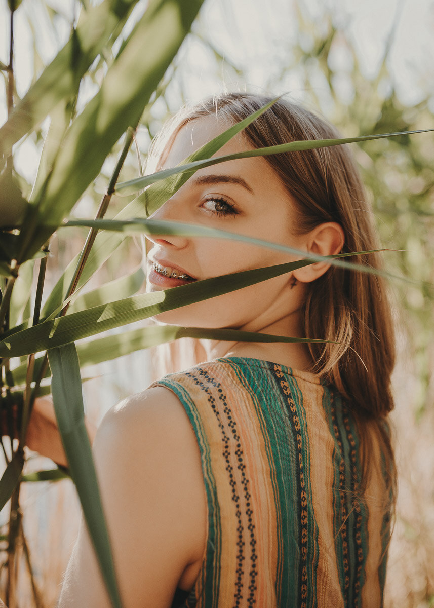Outdoor-Portrait einer jungen Frau im Schilf während der Golden Hour, bearbeitet mit Hey Poly Lightroom Presets