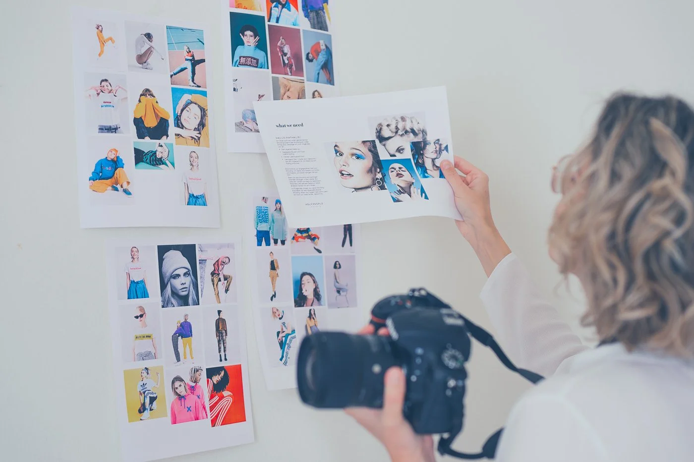 Portrait von Julia Feldmann von Hey Poly Photoart Studio mit ihren Moodboards an der Wand, bearbeitet mit dem Hey Poly Preset Jade