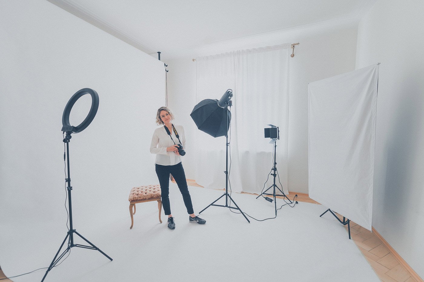Fotografin Julia Feldmann von Hey Poly in einem professionellen Fotostudio mit Studioausrüstung und einem weißen Hintergrund.