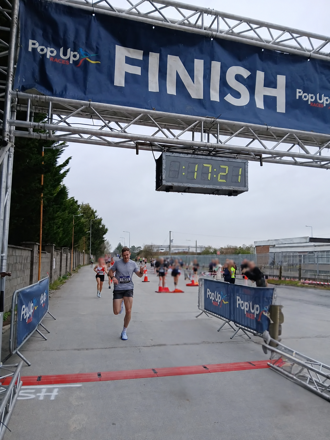 Kieran Lillis crossing the finish line of a 5K race.
