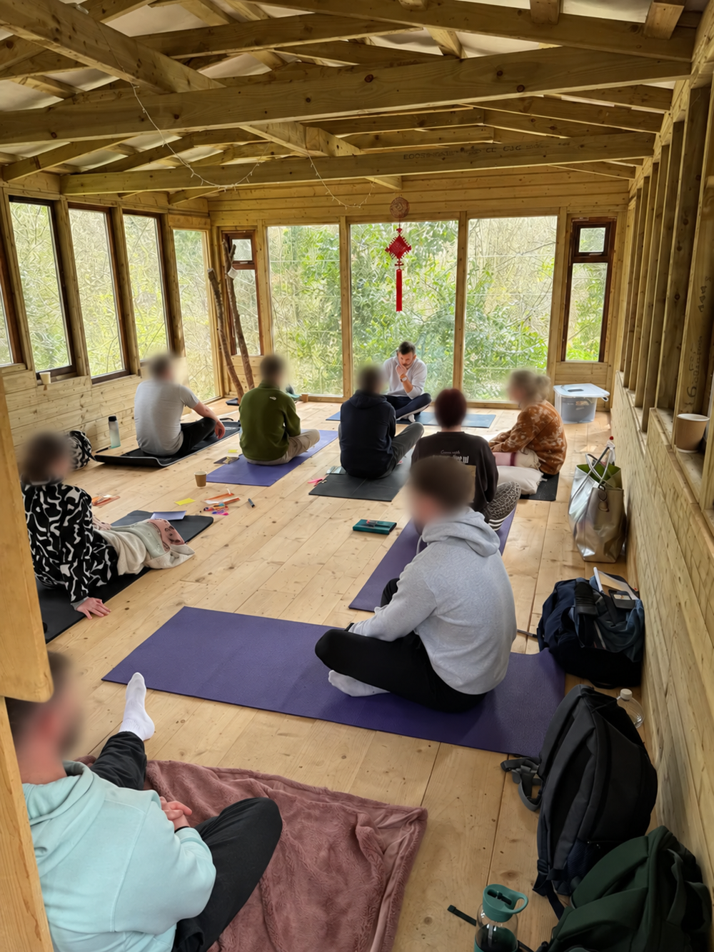 Kieran Lillis facilitating a breathwork session, with participant faces blurred for privacy.