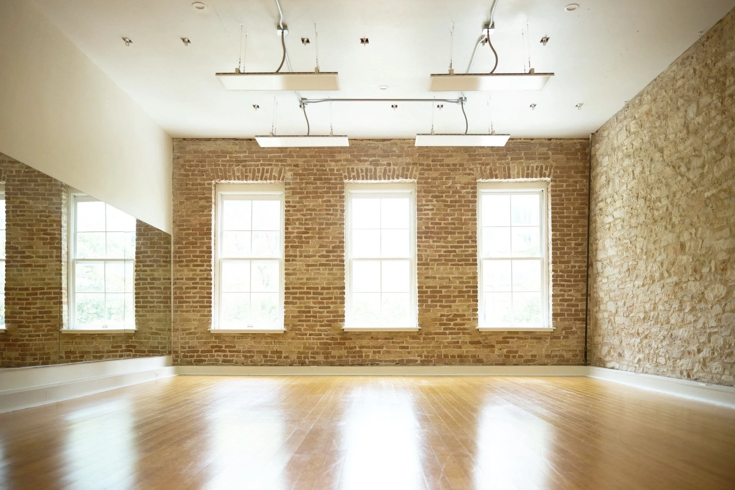 Yoga hŌM’s heated studio with natural light, large windows, and mirrors—home to hot Pilates and heated vinyasa yoga classes.