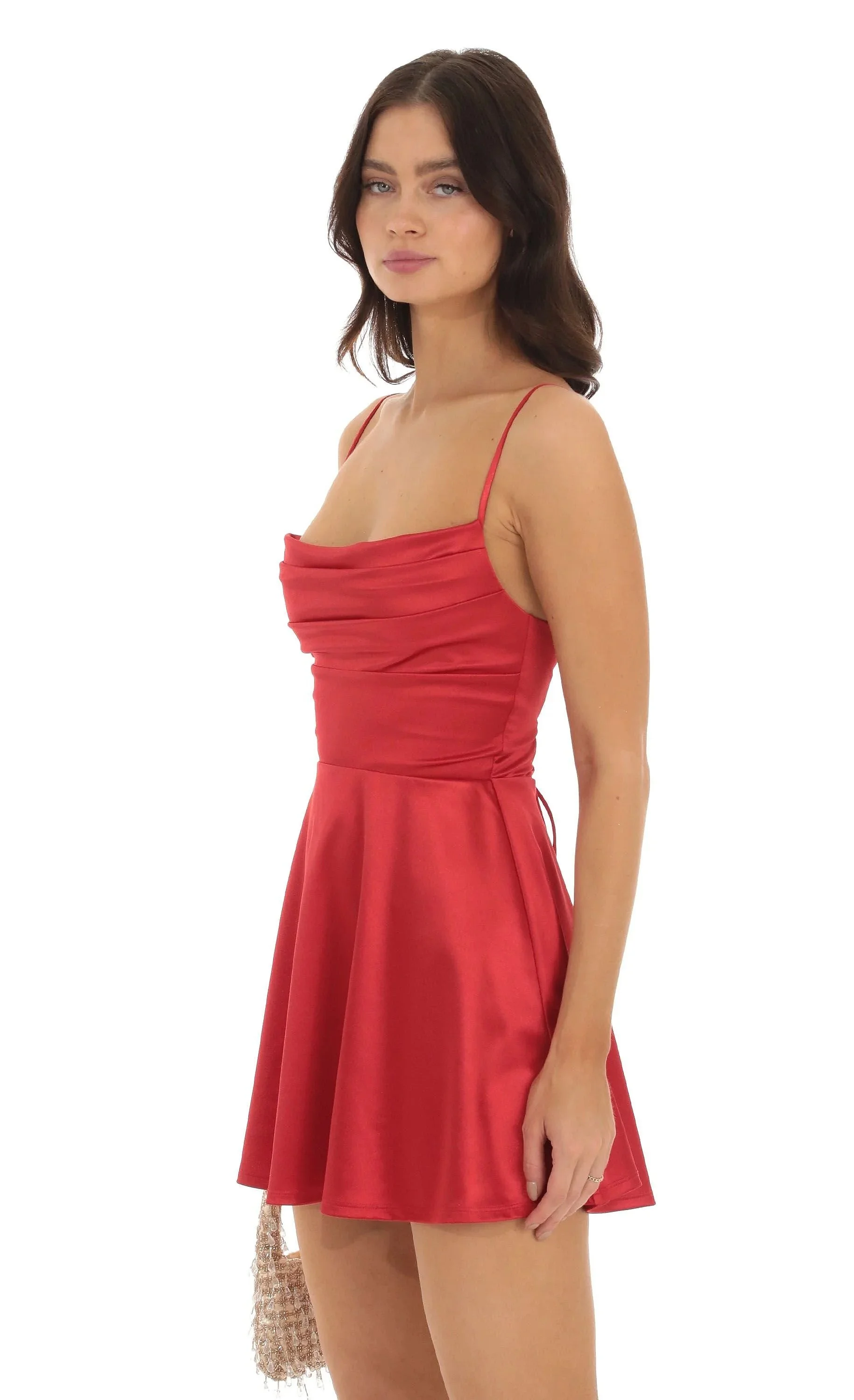 Side view of elegant red satin mini dress featuring a soft cowl neckline, adjustable spaghetti straps, and a flowing A-line skirt.
