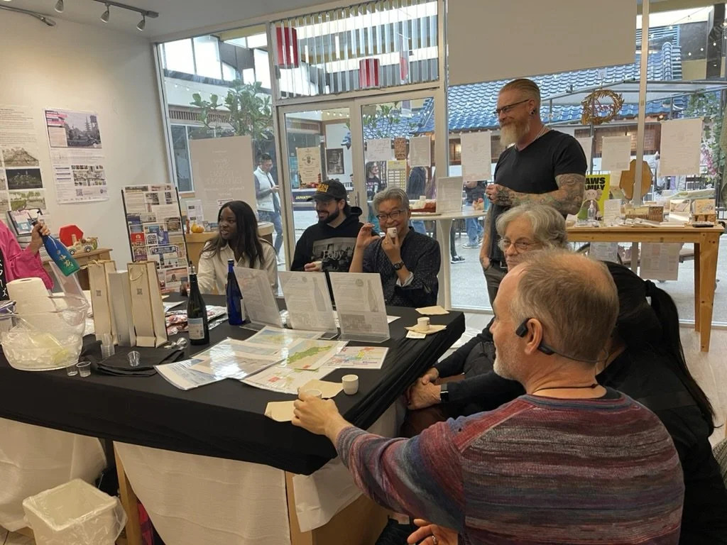 Group of six people listening to the Sake Trend expert explaining how the sake is made.