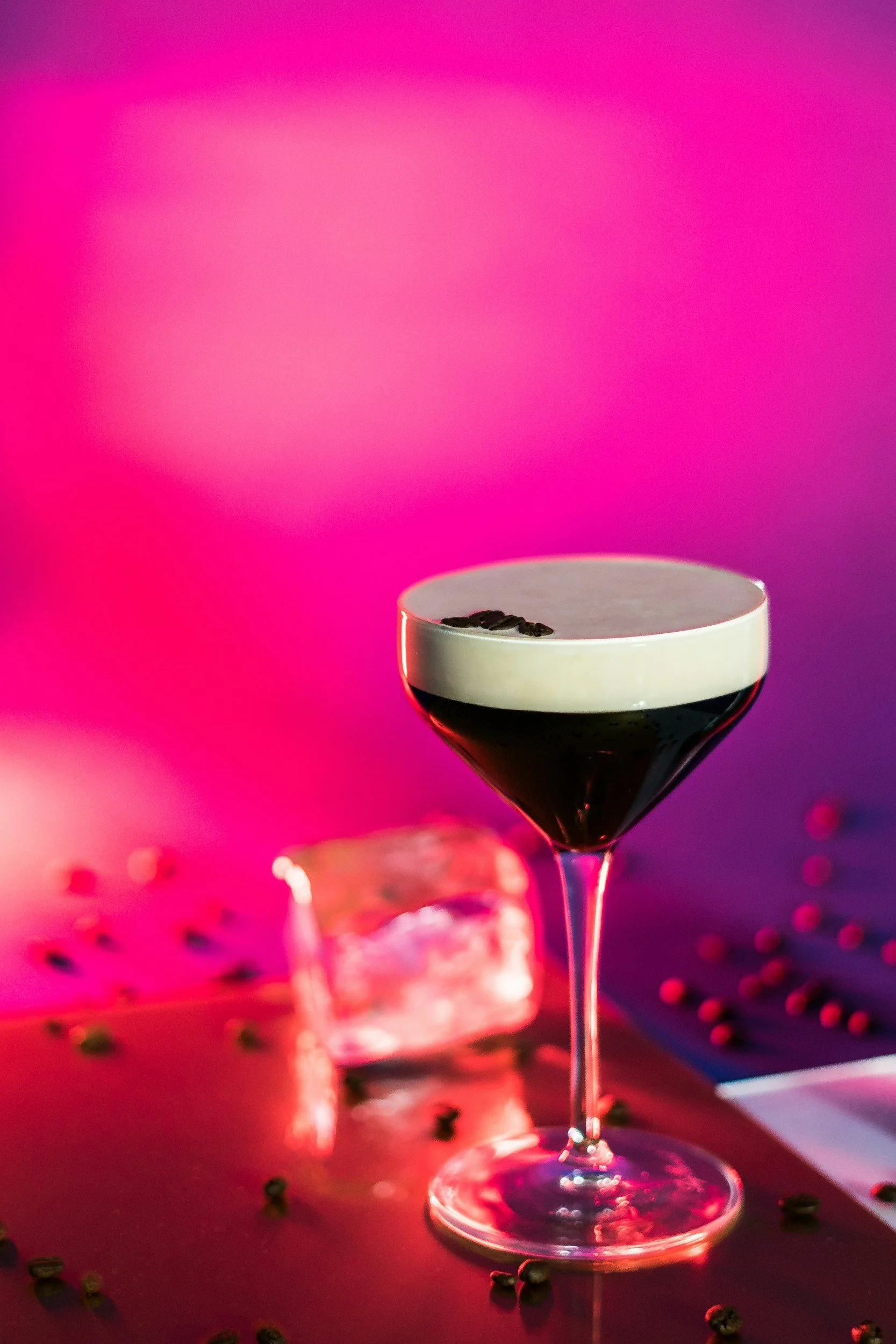 image of an espresso martini in front of a pink and orange background