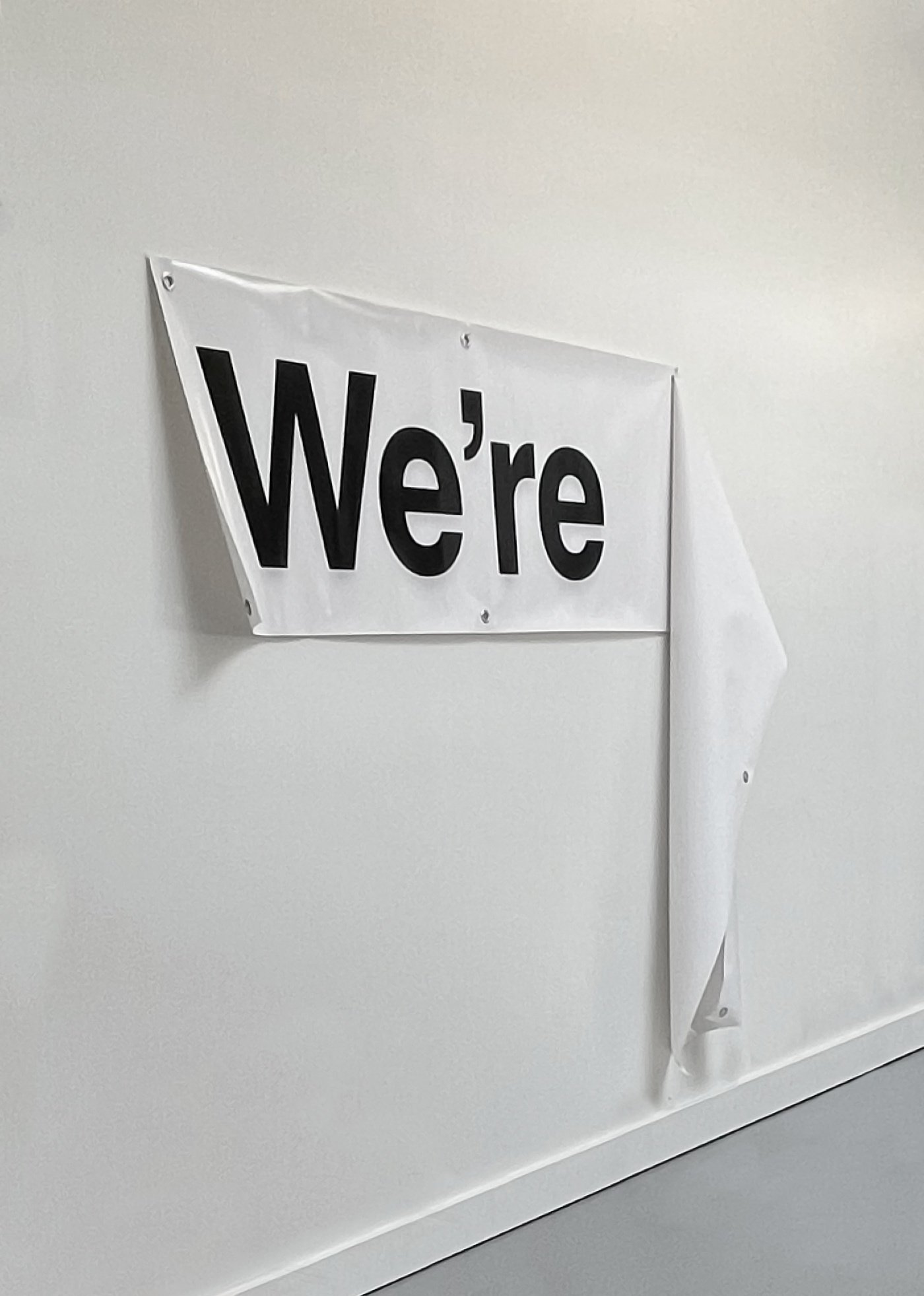 Zak Jensen, We're..., Vinyl, metal grommets, 110 x 18 inches, 2025, NFS