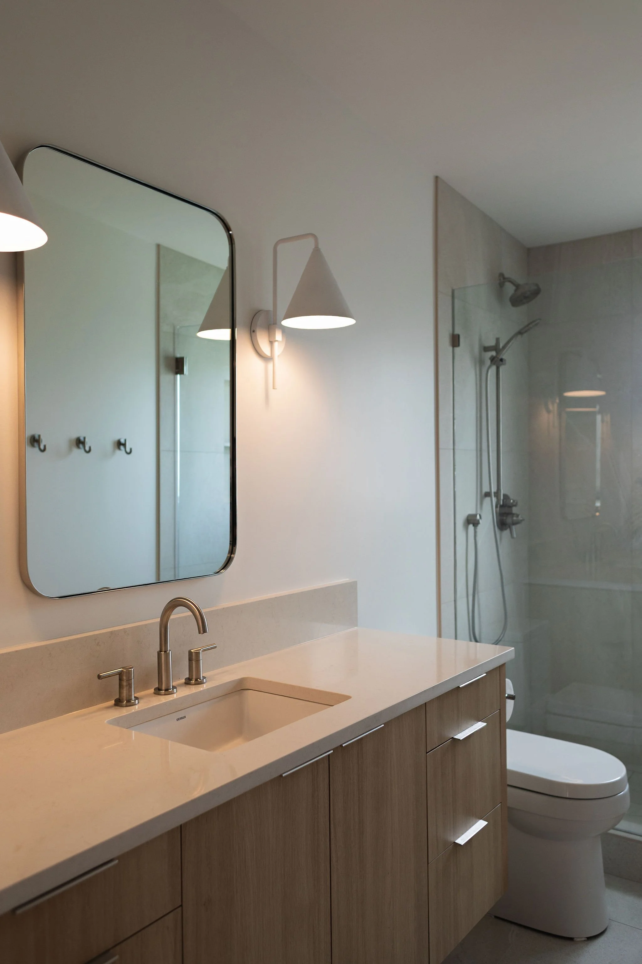 Modern bathroom with custom white oak vanity and textured tile.