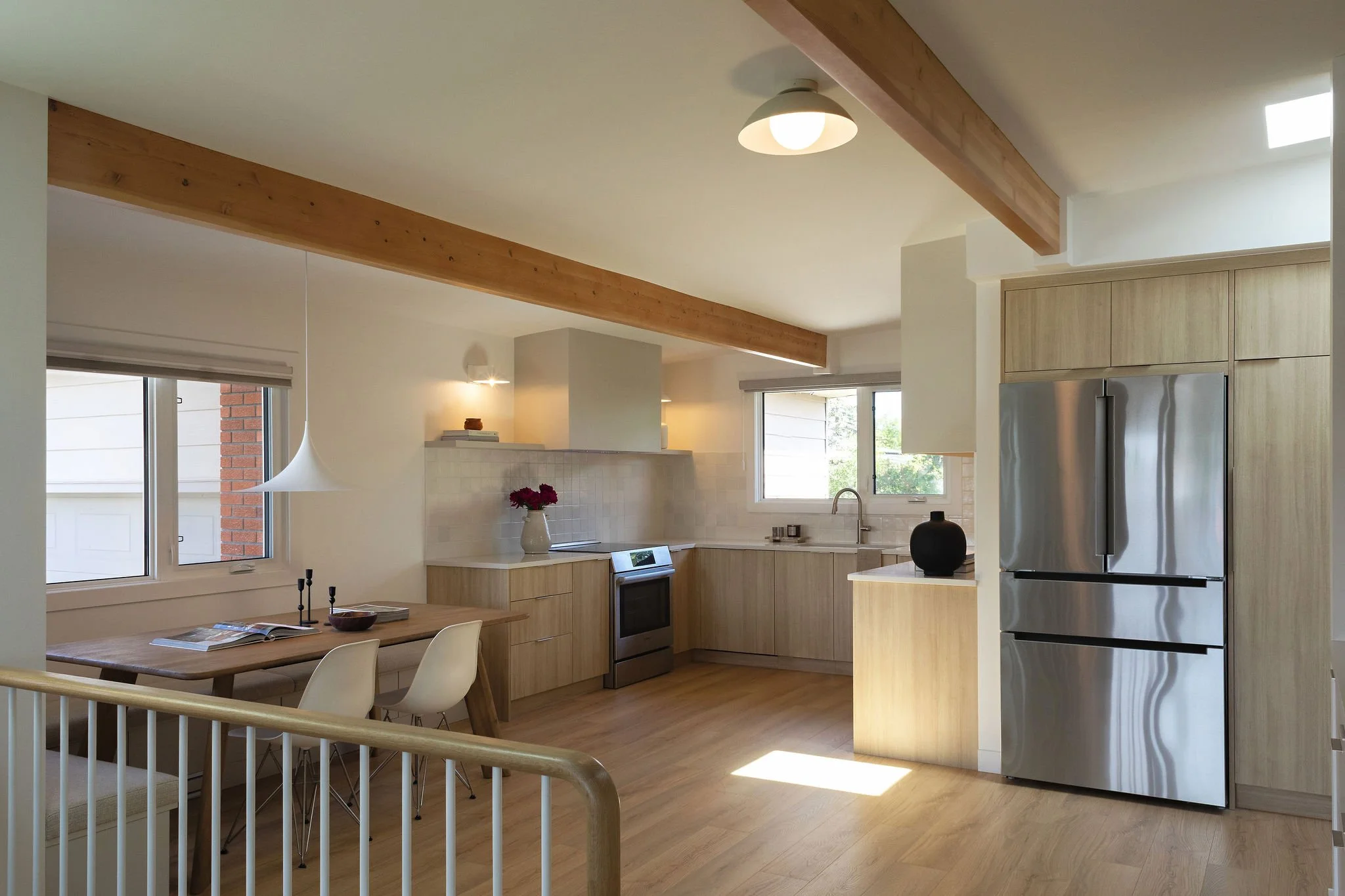 Modern kitchen featuring integrated appliances and statement pendant lighting.