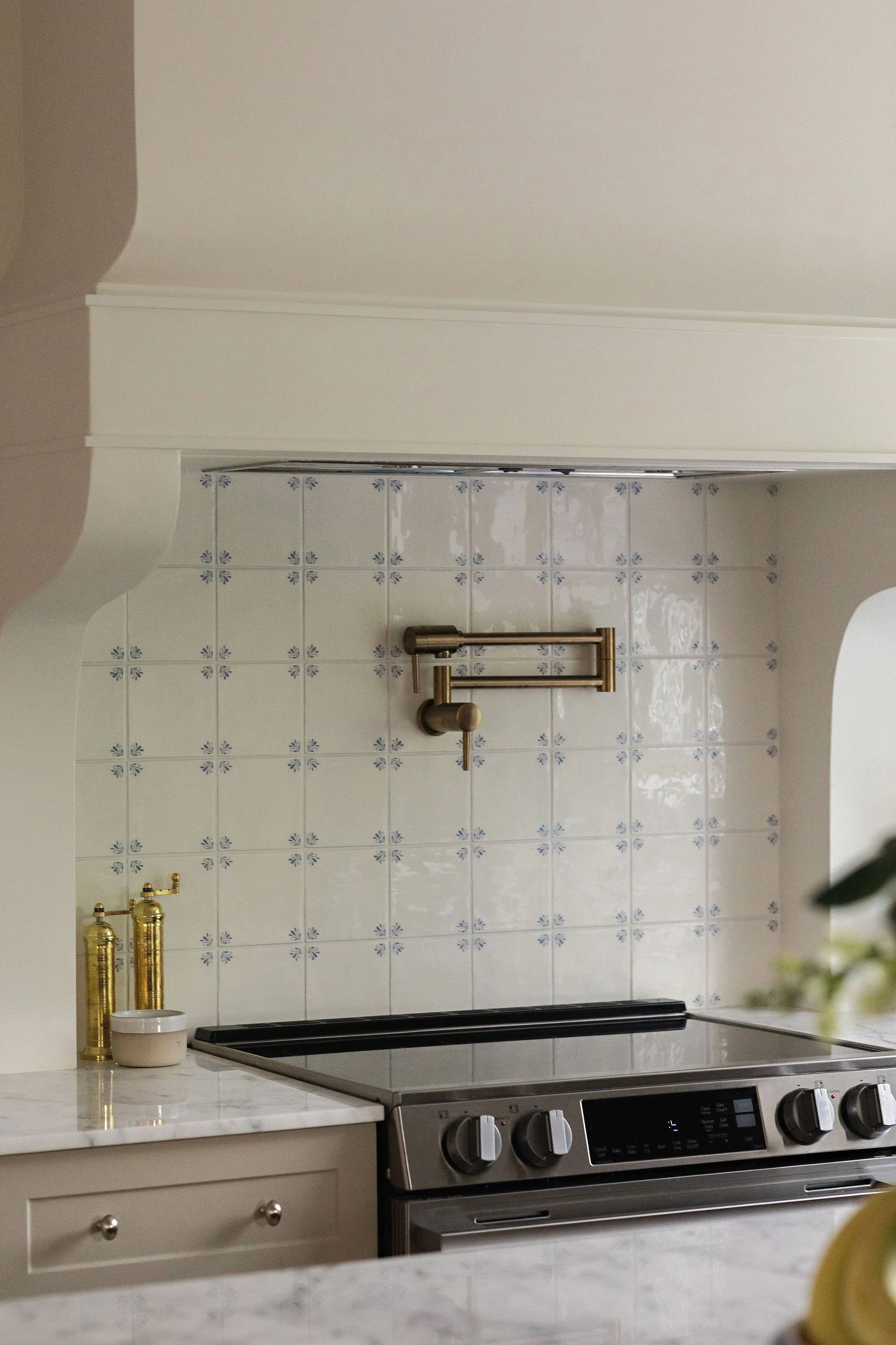 Kitchen backsplash with Delft-inspired patterned tile adding subtle blue accents to a charming cottage renovation.