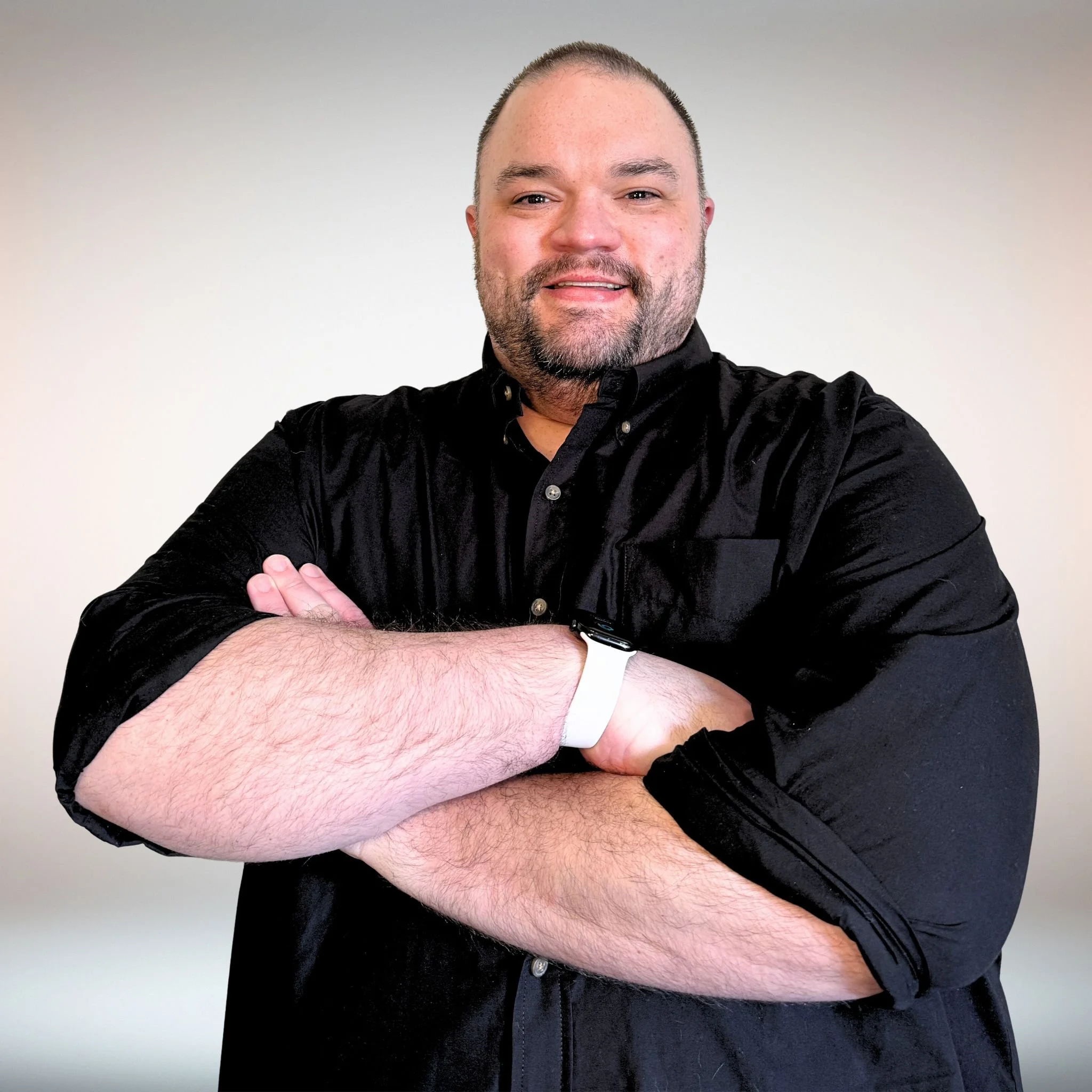 Headshot of Brandon Burkman with crossed arms and smiling.