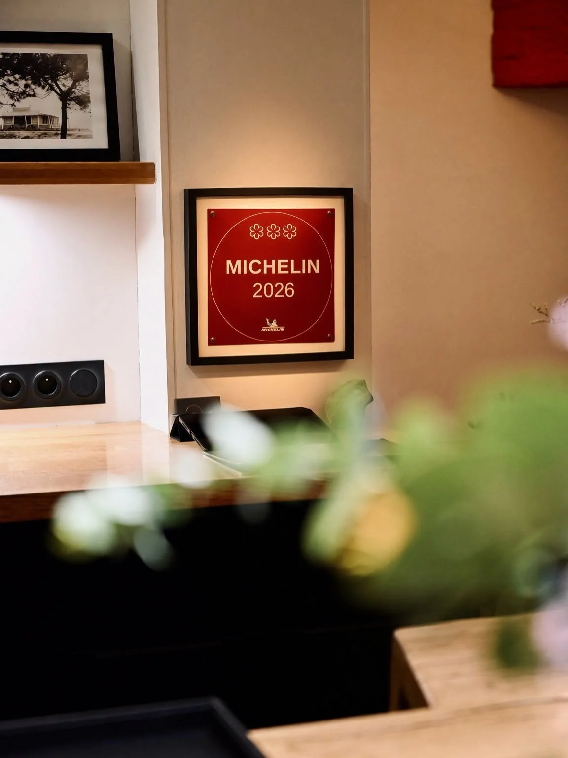Plaque Guide Michelin 2026 trois étoiles accrochée au mur de la salle du restaurant AM à Marseille