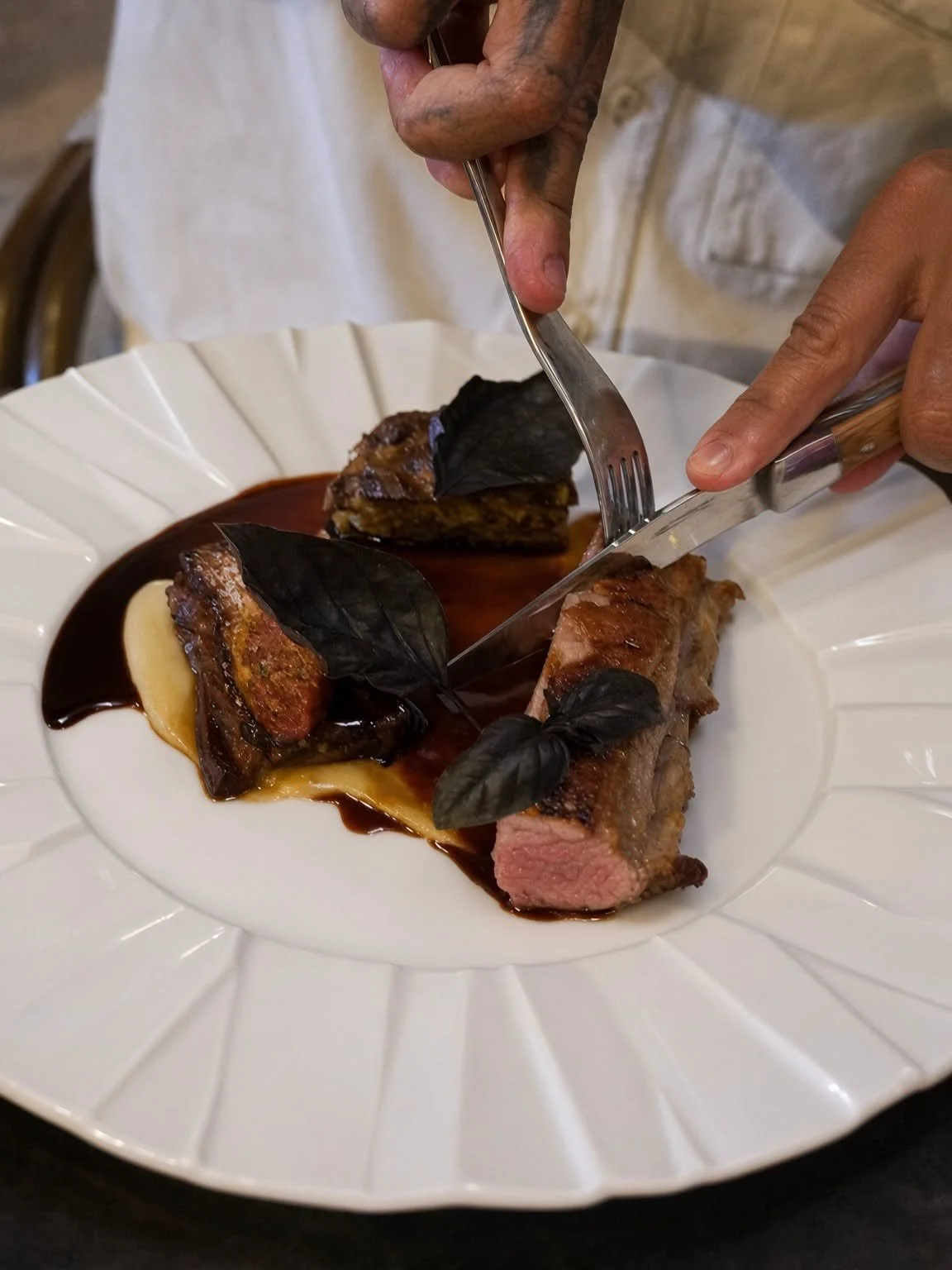 Découpe d'une pièce de viande à table au restaurant Le Jas