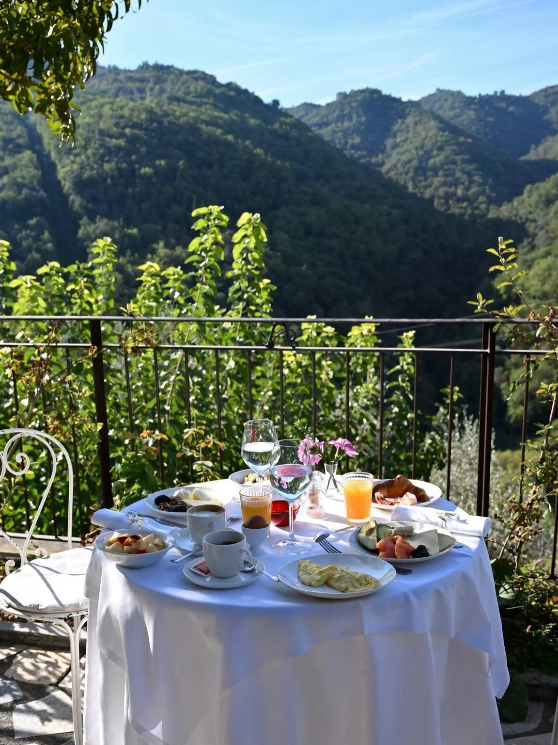 Table de petit-déjeuner dressée sur la terrasse de l'Apricus Locanda face aux montagnes