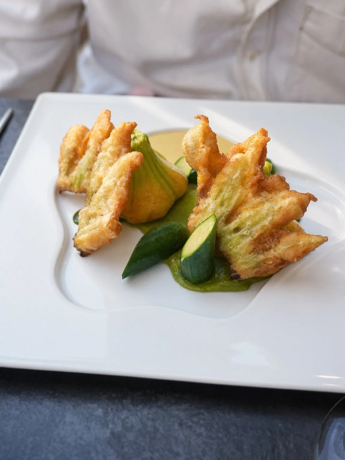 Fleurs de courgette croustillantes servies sur une assiette blanche