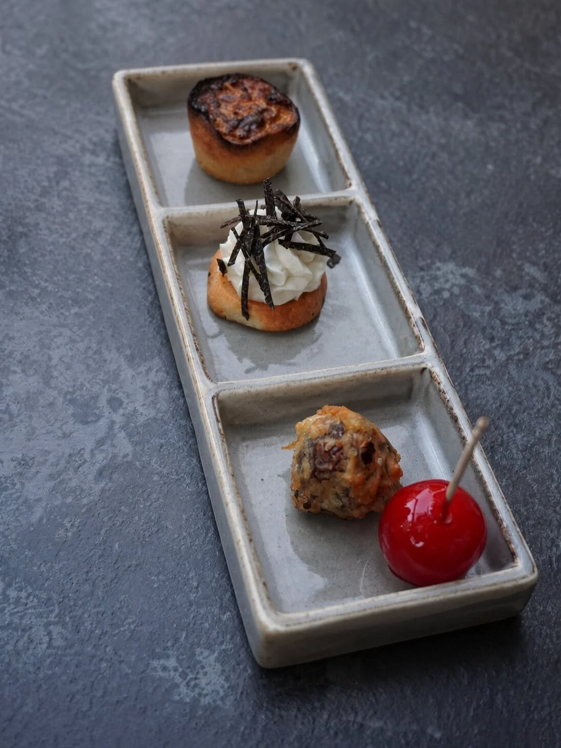 Trio de mises en bouche présenté sur un plat long à compartiments
