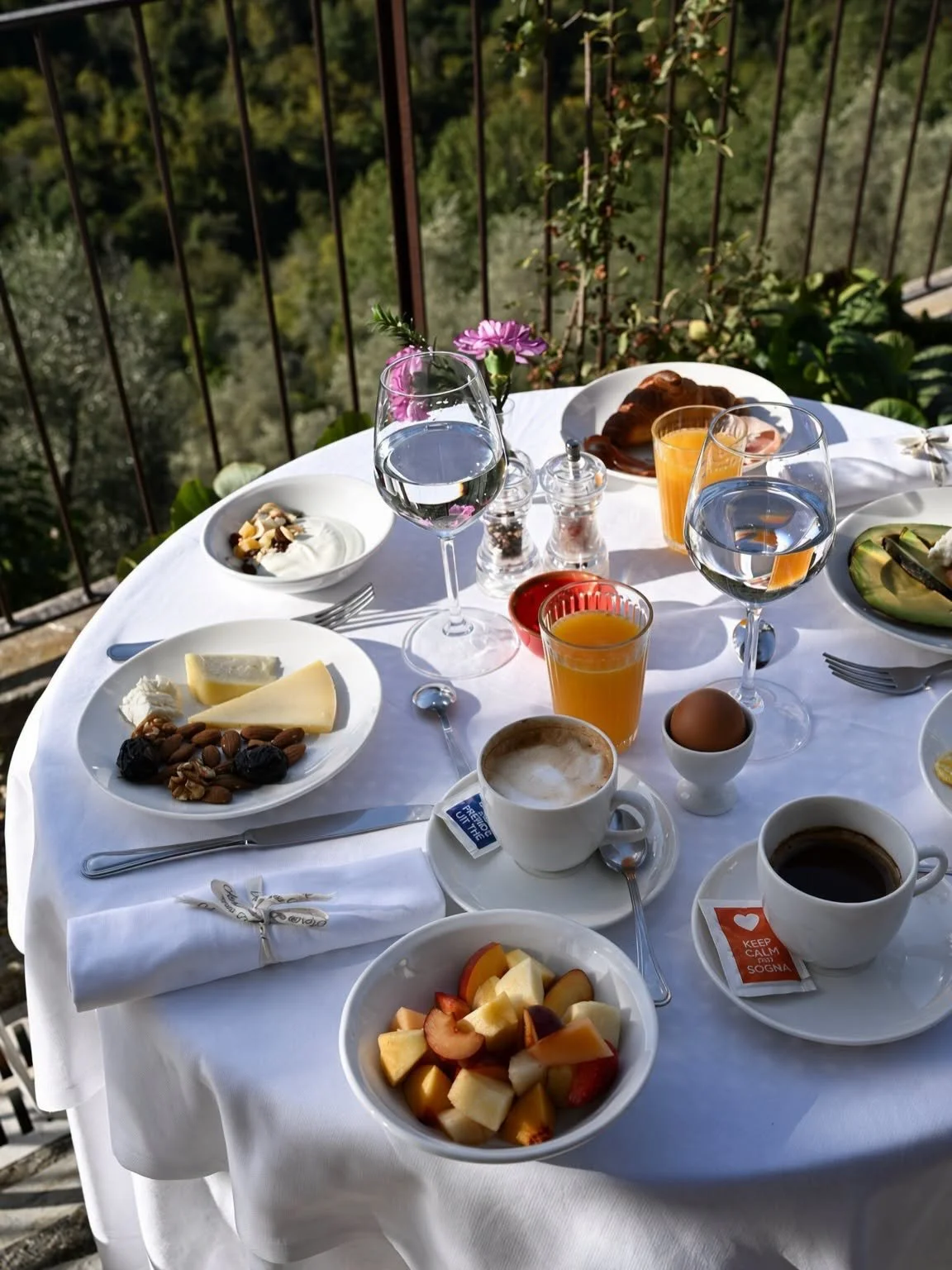 Petit-déjeuner avec fruits, jus d'orange et café sur une table en terrasse