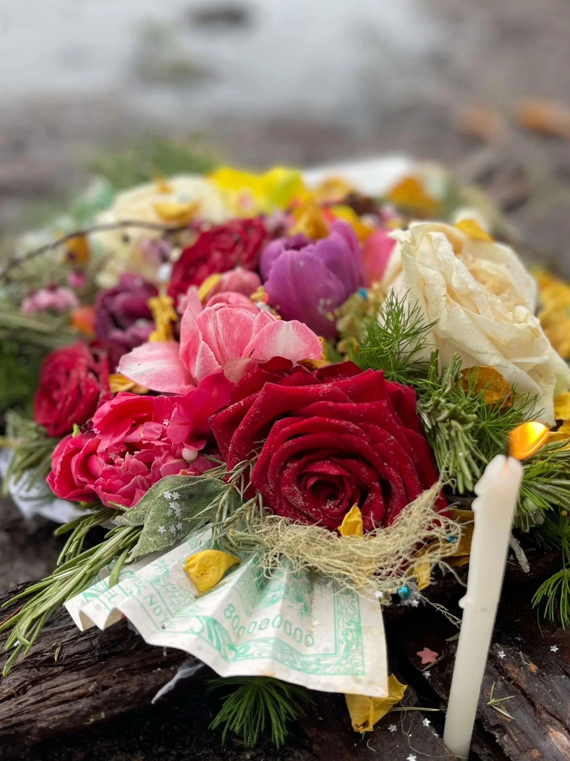Eine große rituelle Gabe mit Rosen, Blüten, Heilpflanzen, Geldscheinen kurz vor der Übergabe an einen See im Rahmen einer Business Bloom Ritual-Prozessarbeit