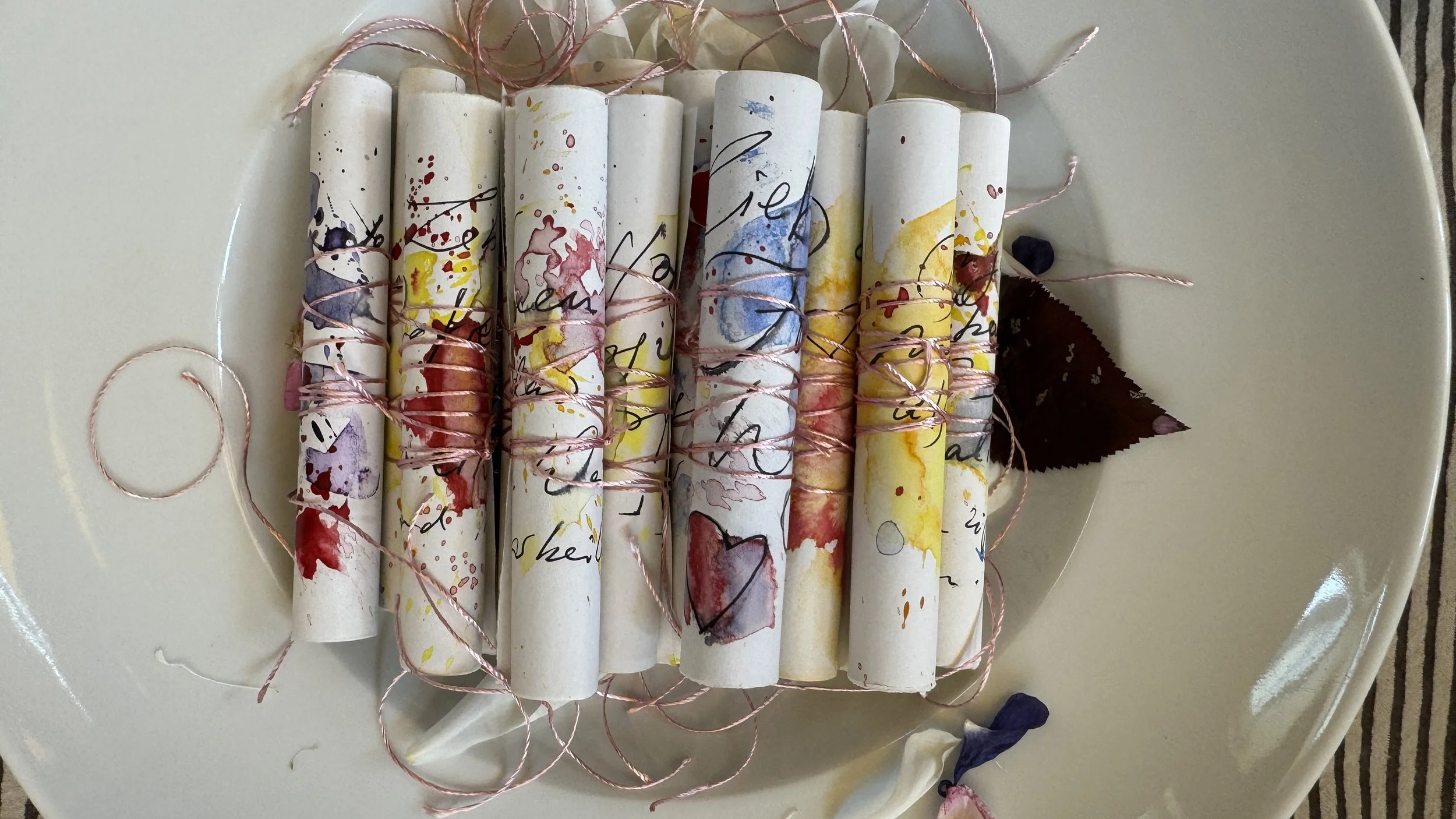 Handgeschriebene Botschaften mit Aquarellierungen zusammengerollt mit seidenen Bändern fertig zur rituellen Übergabe in der Zeremonie