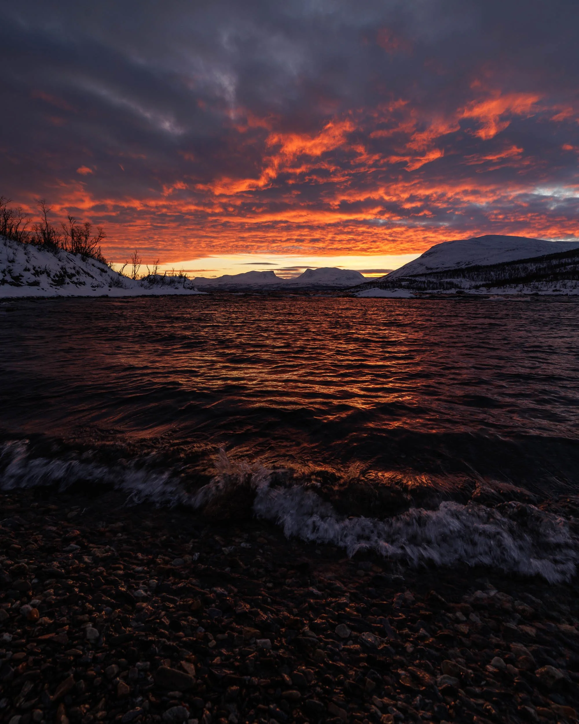 Red sky during a sunrise over lake tornetrask in abisko in winter
