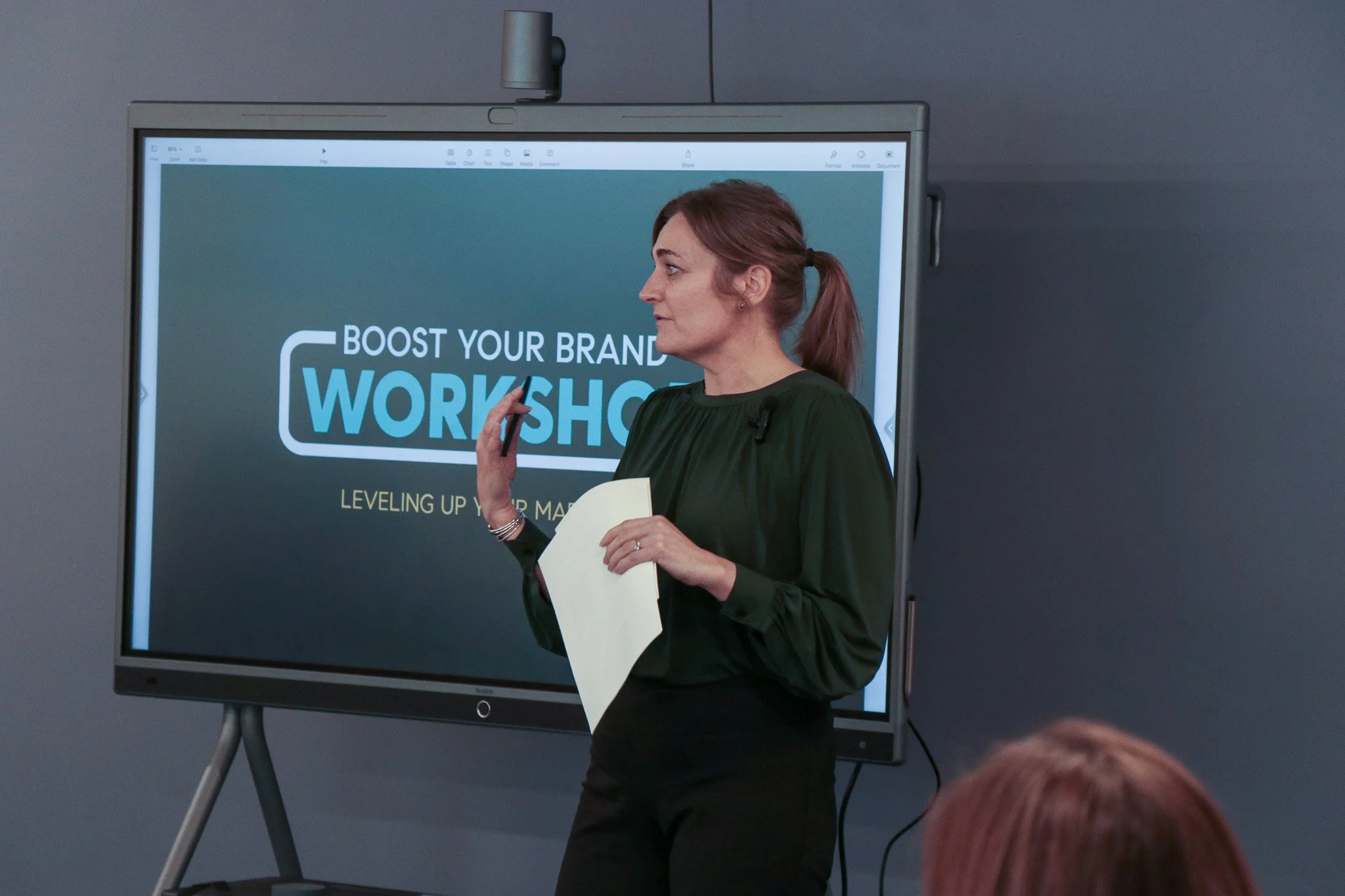 A Boost Your Brand workshop session in progress, with the workshop title on screen at the front of the room