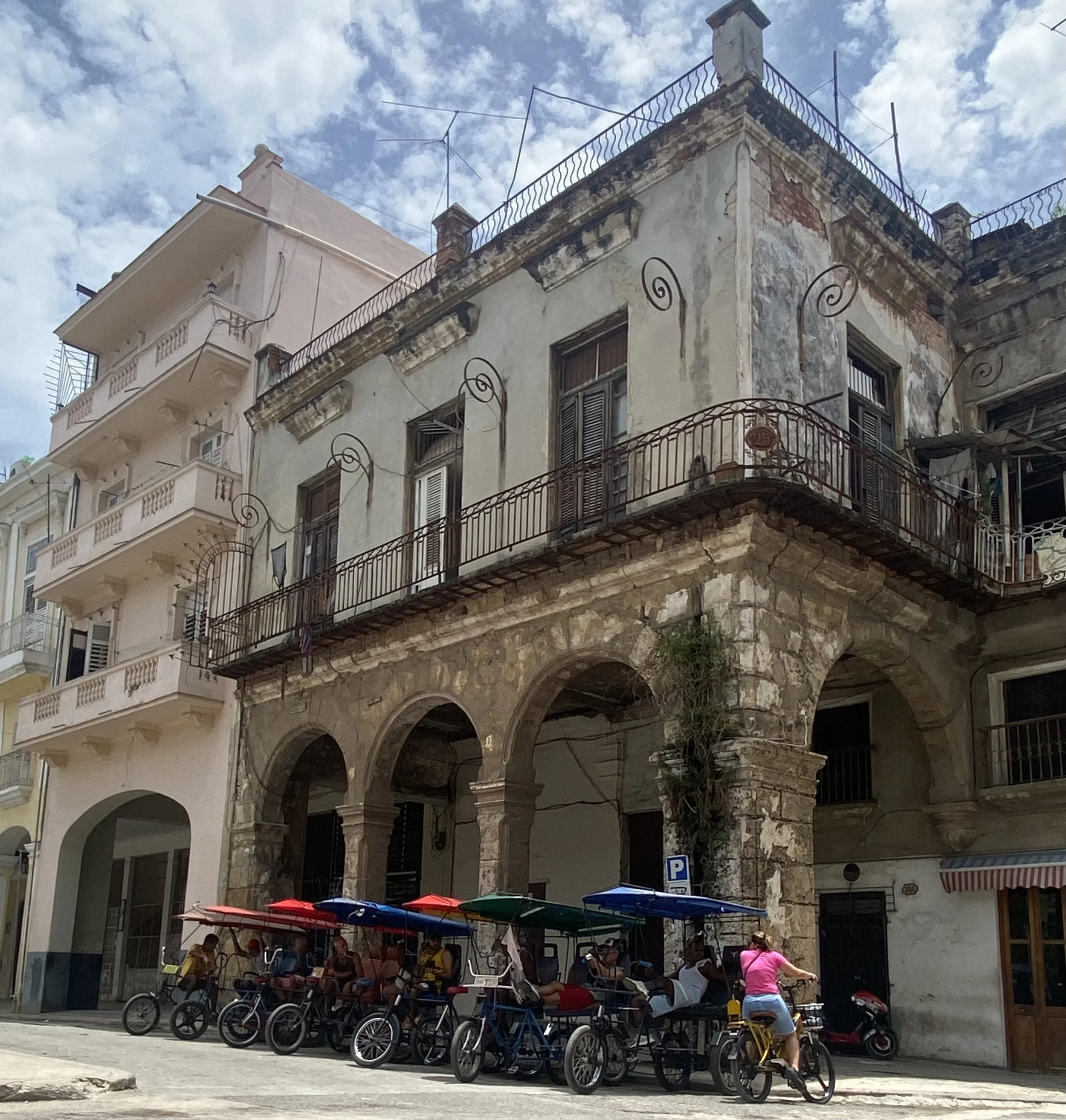 Street corner in Old Havana, in a summer day,  where private sector bicycle taxis wait for customers.