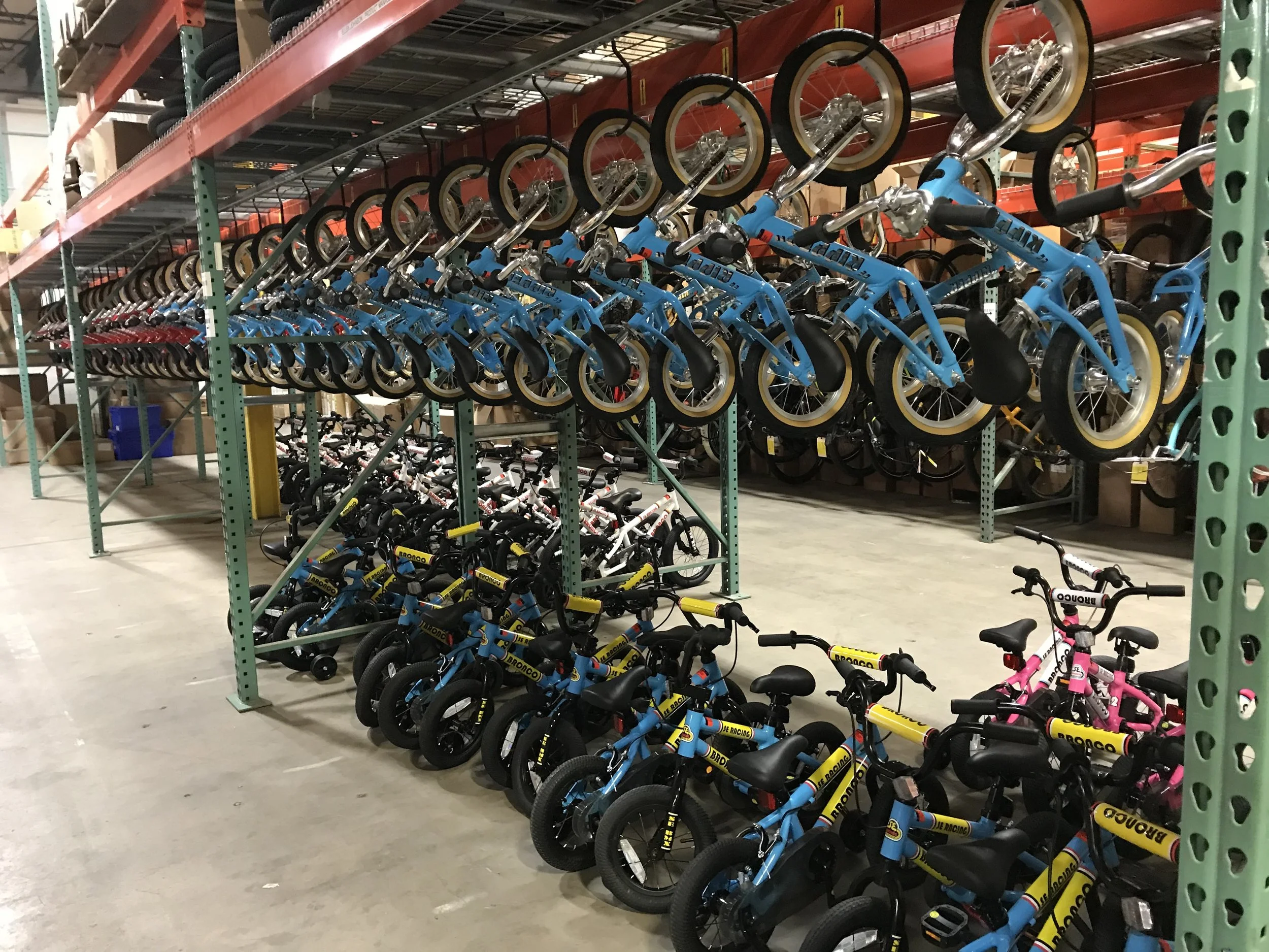 Shelves filled with stacked children's bikes in a warehouse store.