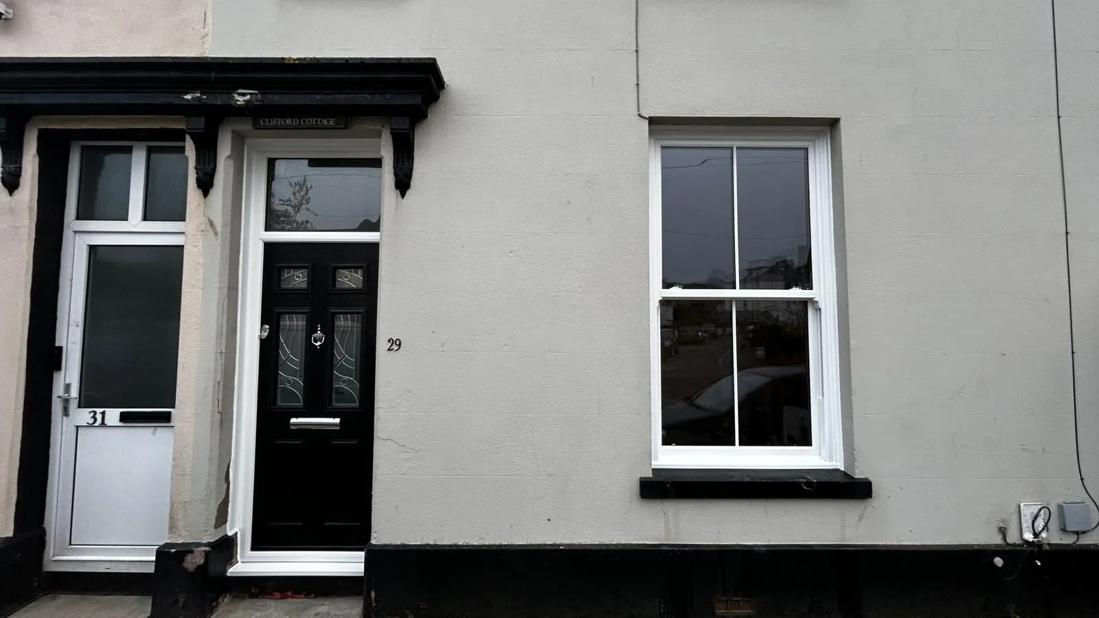 Black composite door and sliding sash window in Devon