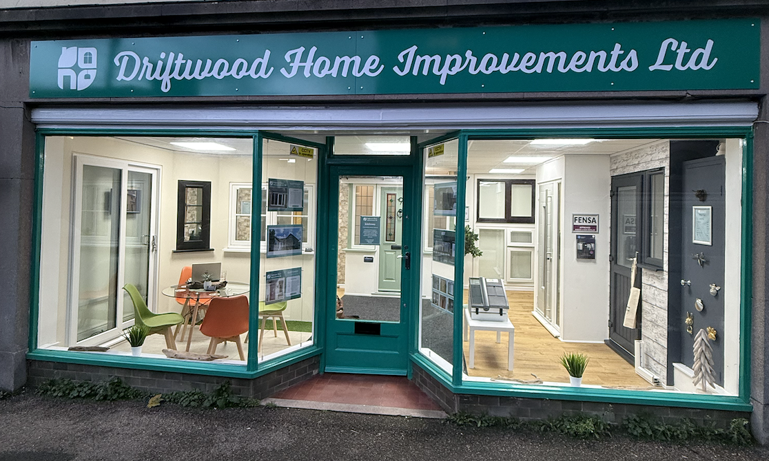Display window of Driftwood Home Improvements Ltd showcasing various home window and door options inside.