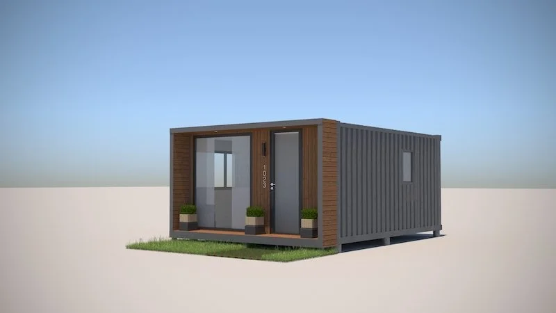 A small, modern tiny house with a container-inspired design, featuring wood accents, a front door, large glass window, and potted plants outside.