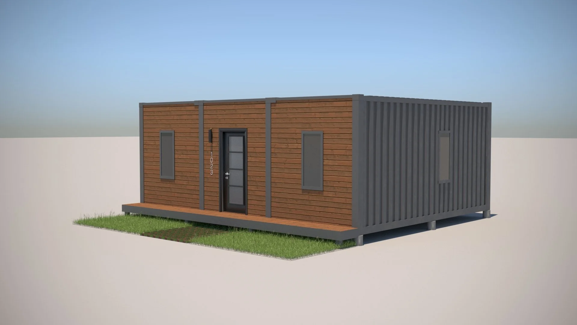 A modern tiny house with wood and dark gray panels, a front door, and three windows, set on a small grassy lot under a blue sky.