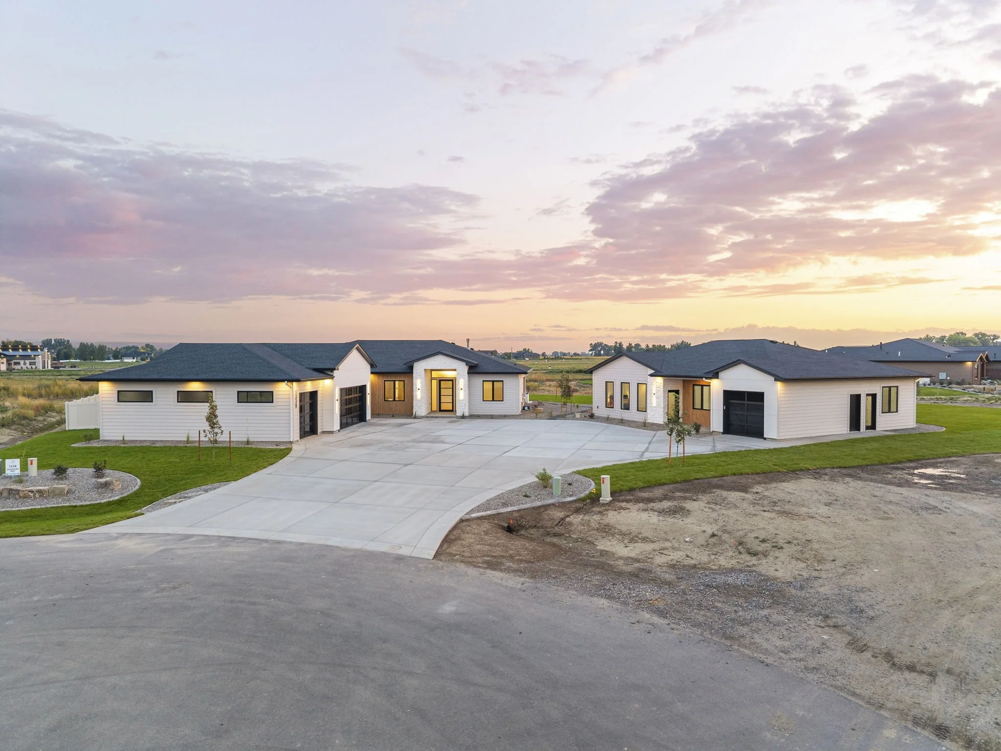 Backyard with patio, outdoor chairs, grill, and a lawn, with a house in the background, under a wooden pergola with string lights.