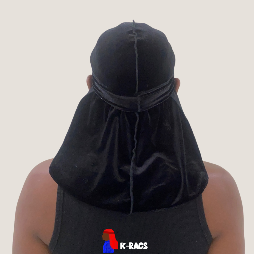 Person seen from behind wearing a black durag and black tank top, with a beige background.