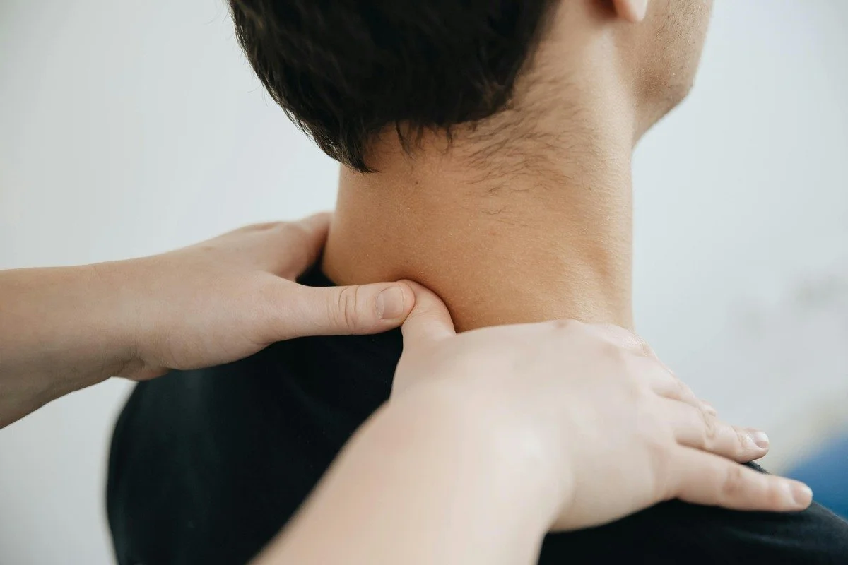 A person receiving a massage on their neck and shoulder area at the Straighten Up Clinic