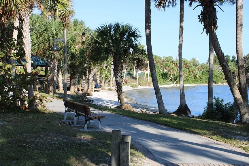 Waterfront walking path and benches at Castaways Point Park in Palm Bay, Florida.