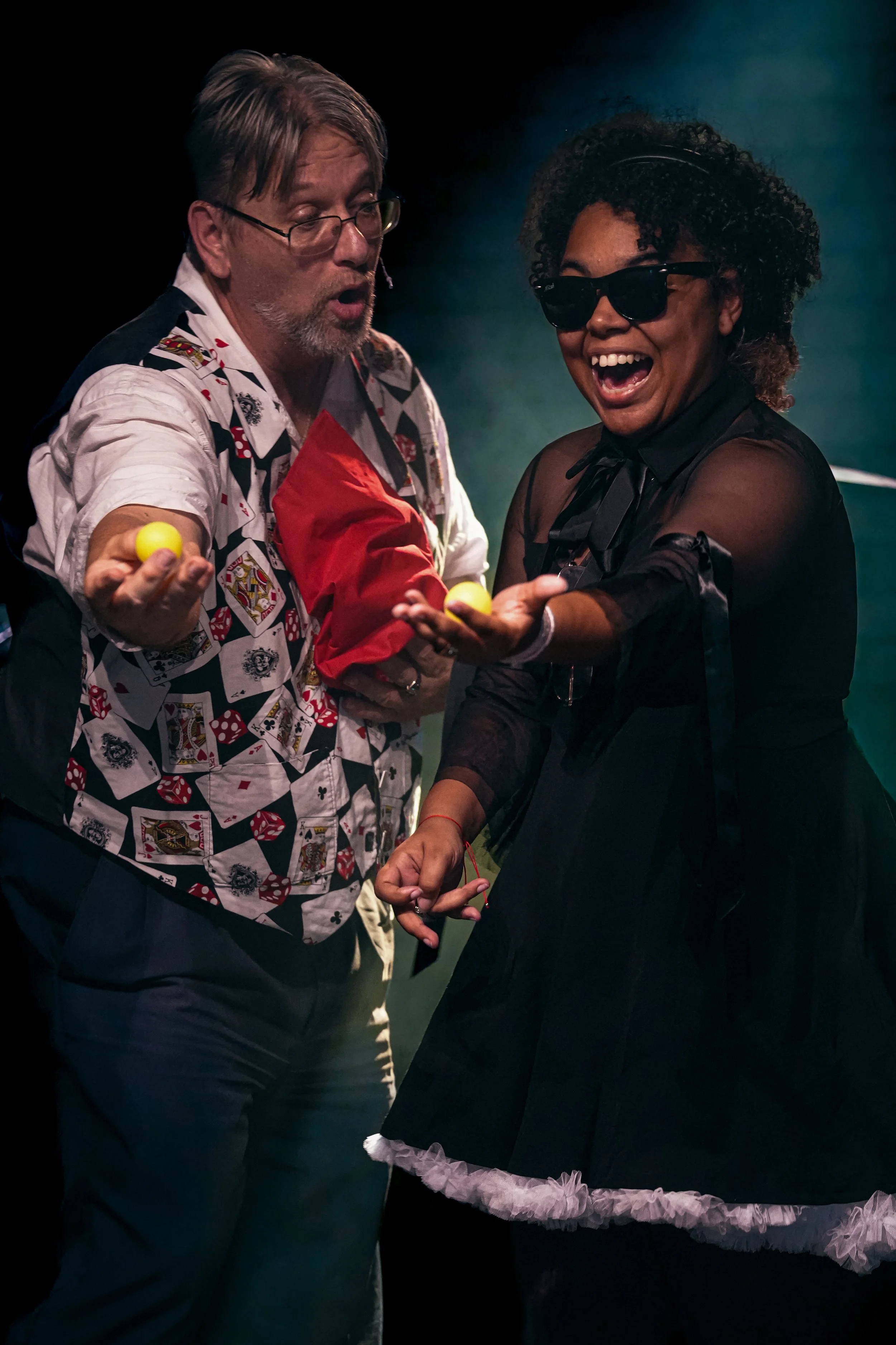 A magician conducting a magic trick with a participant from the audience.