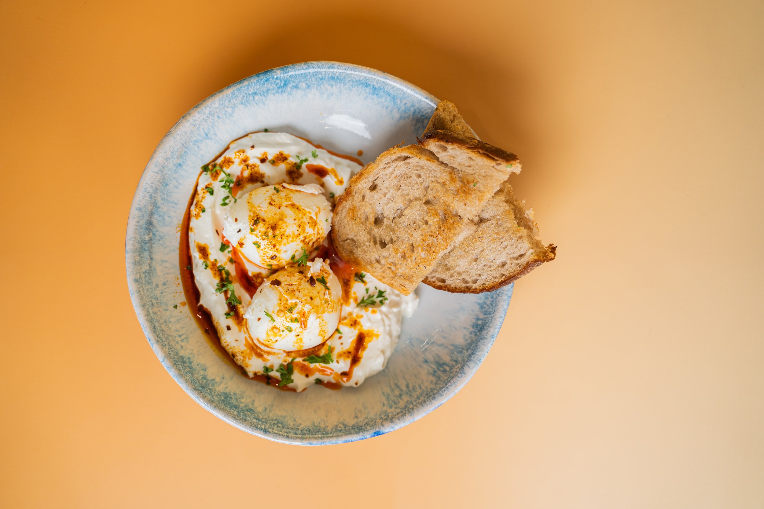 Turkish eggs, housemade Garlicky greek yoghurt and chili oil with local sourdough from chiang mai. a unique breakfast