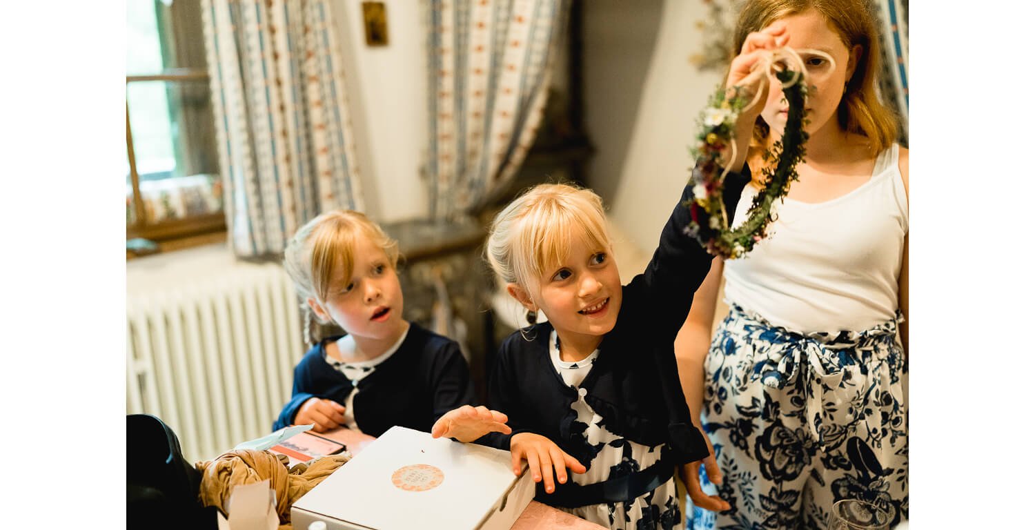 Kinder beim Getting Ready im Ferienhaus St. Hubertus in Grainau, sie halten einen Blumenkranz in den Händen