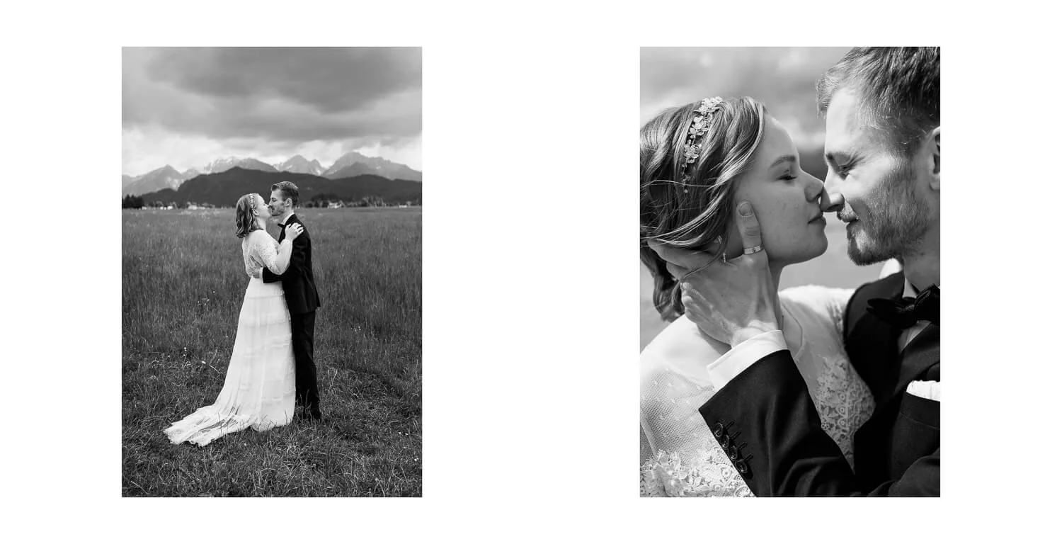 Paarshooting auf einer Wiese bei Füssen, Brautpaar küsst sich vor alpiner Bergkulisse, emotionale Hochzeitsfotos in Schwarzweiß