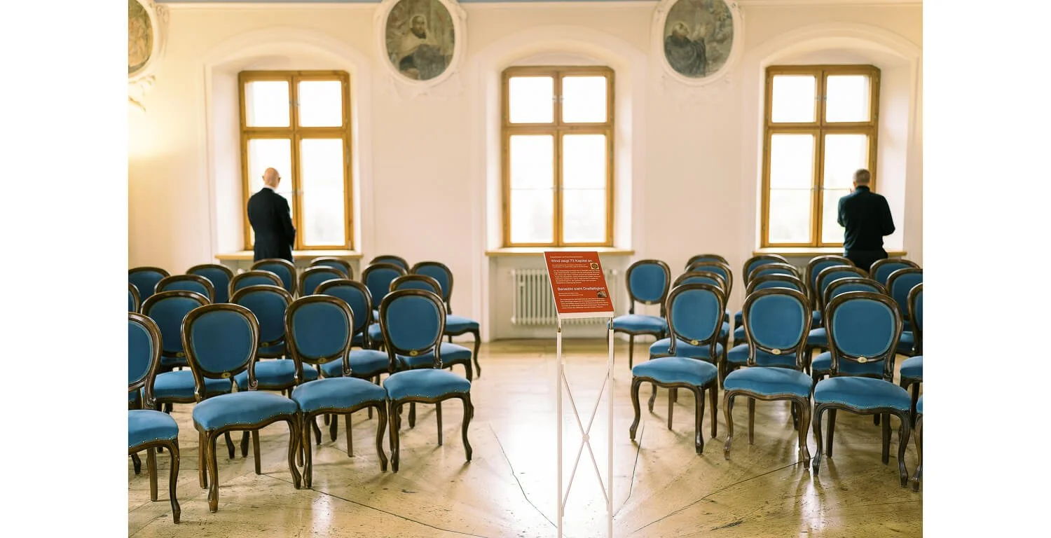 Leerer Saal mit Stuhlreihen und Fenstern im Kloster St. Mang in Füssen