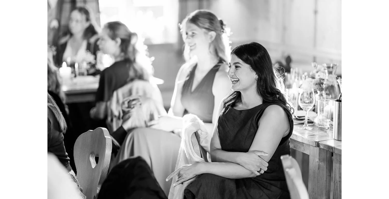 Hochzeitsgäste lachen während der Feier auf der Gamsalm in Ehrwald, Tirol.
