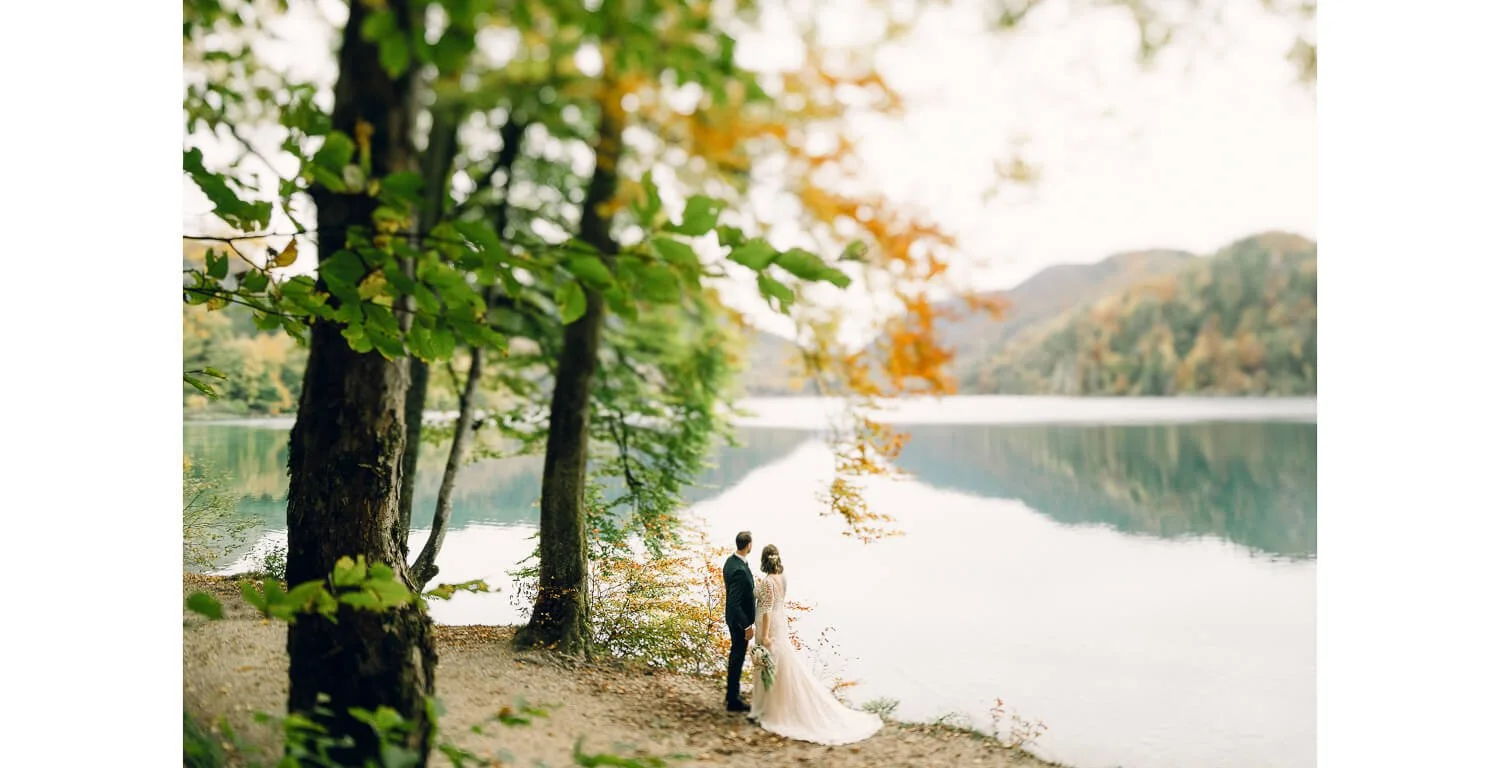 Brautpaar beim Paarshooting am Alpsee bei Schwangau, umgeben von Wald und Berglandschaft