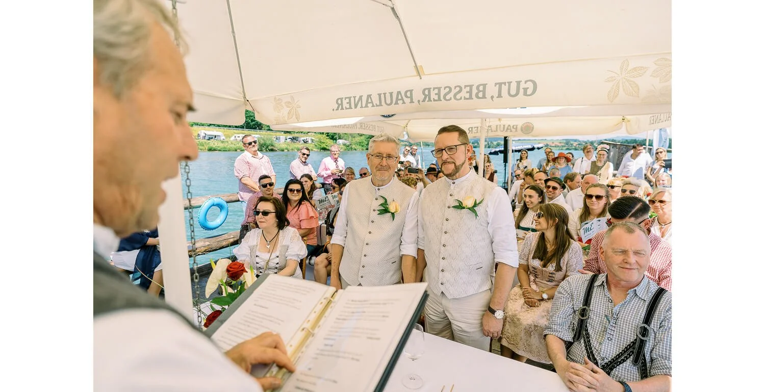 Standesamtliche Trauung auf einem Floß in Lechbruck am See mit Gästen unter Sonnenschirmen