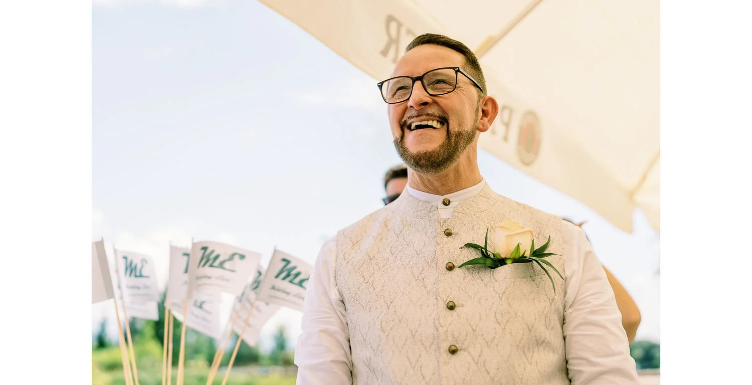 Bräutigam lacht während der standesamtlichen Hochzeit auf einem Floß in Lechbruck am See