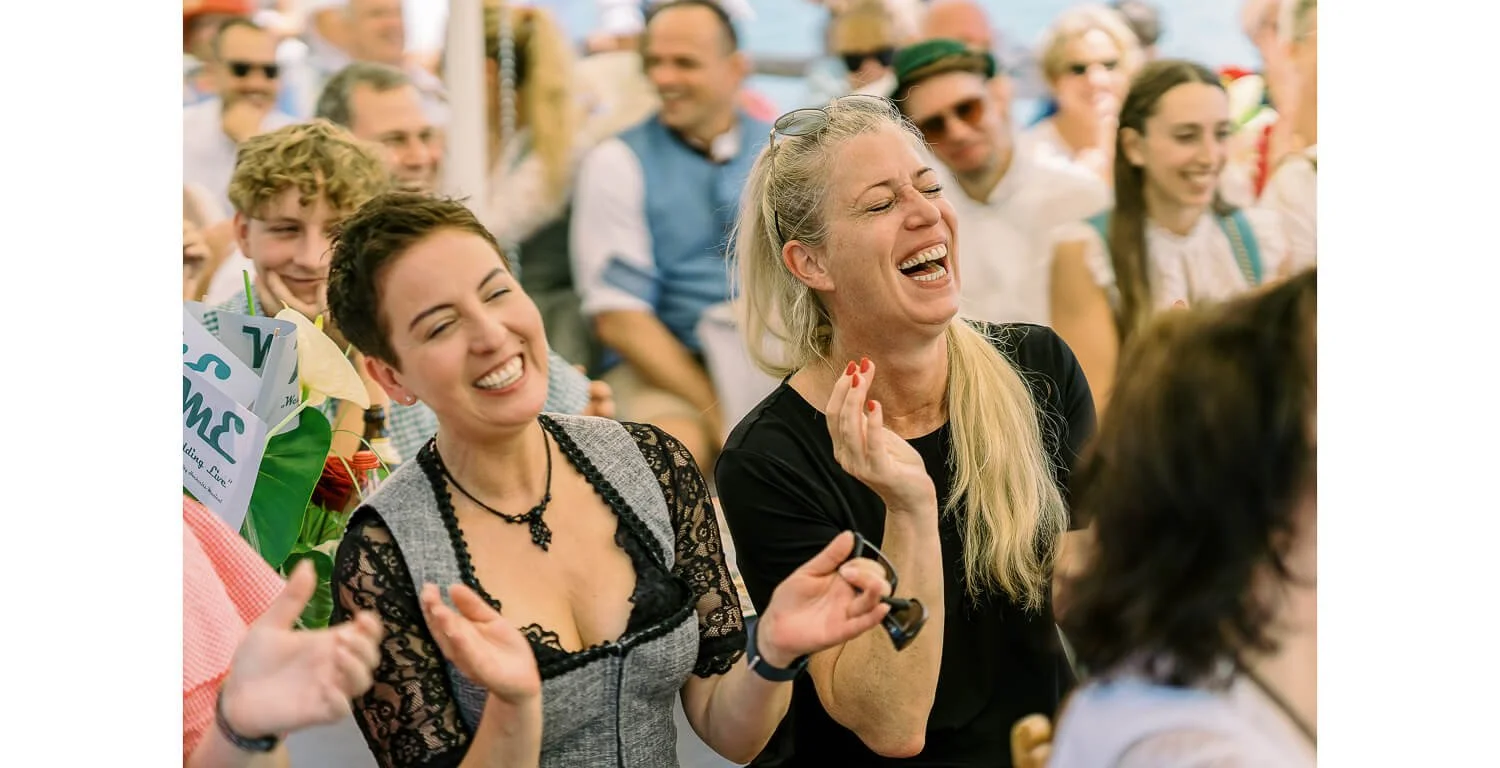 Gäste lachen und klatschen bei einer standesamtlichen Hochzeit auf dem Floß in Lechbruck am See