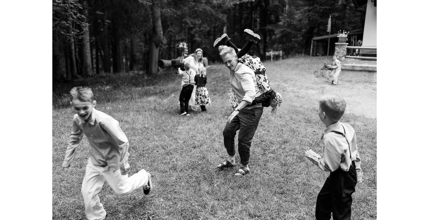 Familie und Kinder spielen nach der freien Trauung im Wald in Grainau, schwarz-weiß Fotografie