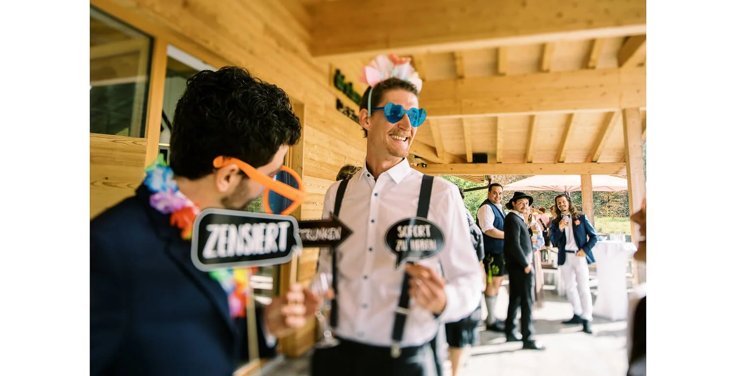 Gäste mit Fotobox-Requisiten bei einer Hochzeitsfeier im Schanzenwirt in Oberstdorf