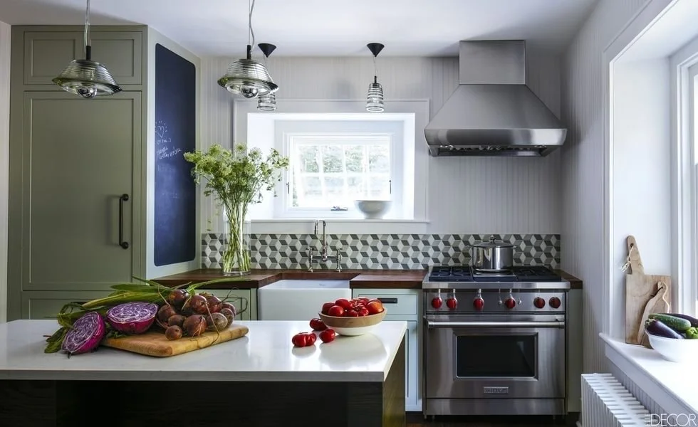 Kitchen with a farmhouse sink, patterned tile backsplash, and stainless-steel range.