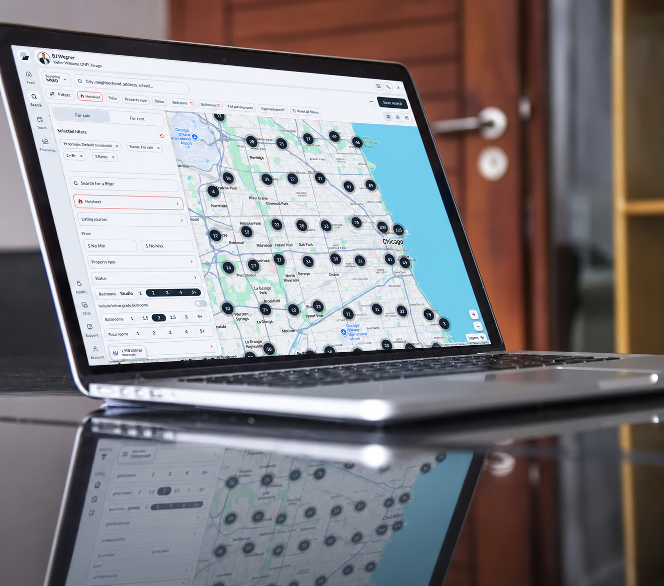 Laptop displaying a Chicago real estate home search with property listings and an interactive map.