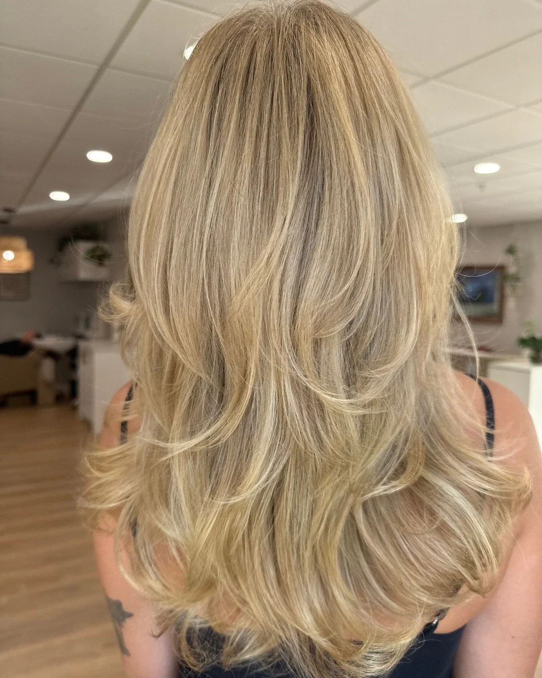 Soft blonde with layers that move and face-framing pieces that highlight your features ✨ This look by @blondedbyzo is full of dimension, texture, and effortless style from every angle 🤩
